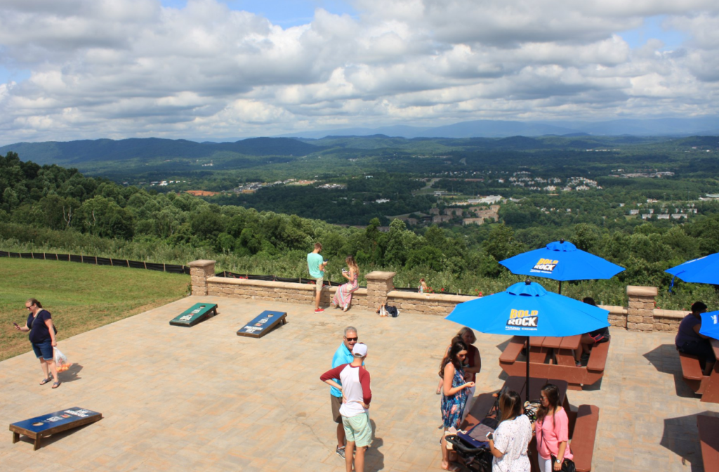 Stone patio at Carter Mountain Orchard with picnic tables and corn hole boards