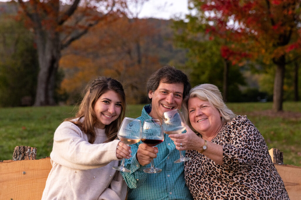 Three people on a bench with wine glasses
